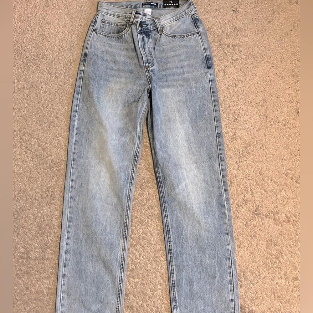 *never worn* light wash asymmetrical button jeans